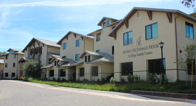 Ronald McDonald House at Stanford – Arrillaga Family Center Exterior of the Ronald McDonald House at Stanford featuring beige siding, gabled roofs, and the Arrillaga Family Center name on the building.
